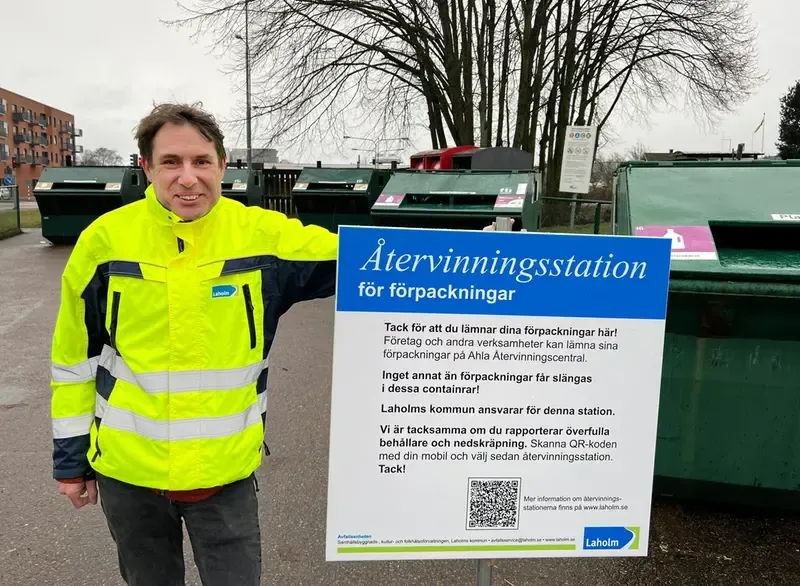 Avfallsingenjör Daniel Zetreus visar ny informationsskylt på en återvinningsstation